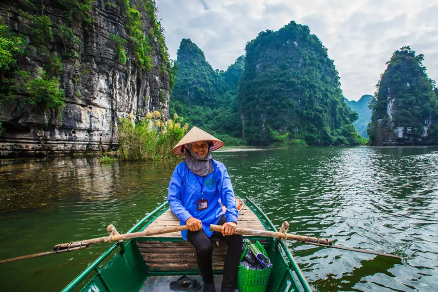 Boat trip through limestone scenery at Trang An in Ninh Binh