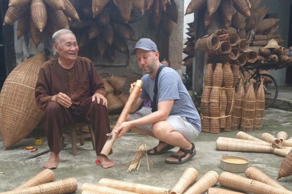 visitor try to use vietnamese bamboo pipe thuoc lao in thu sy village
